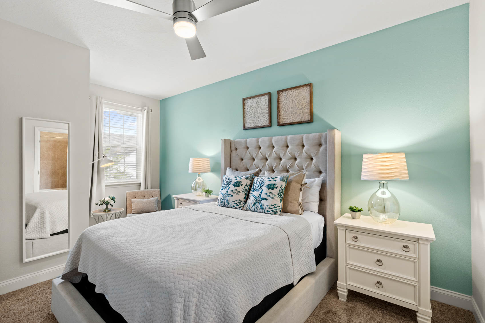 primary suite with white comforter on bed and teal walls